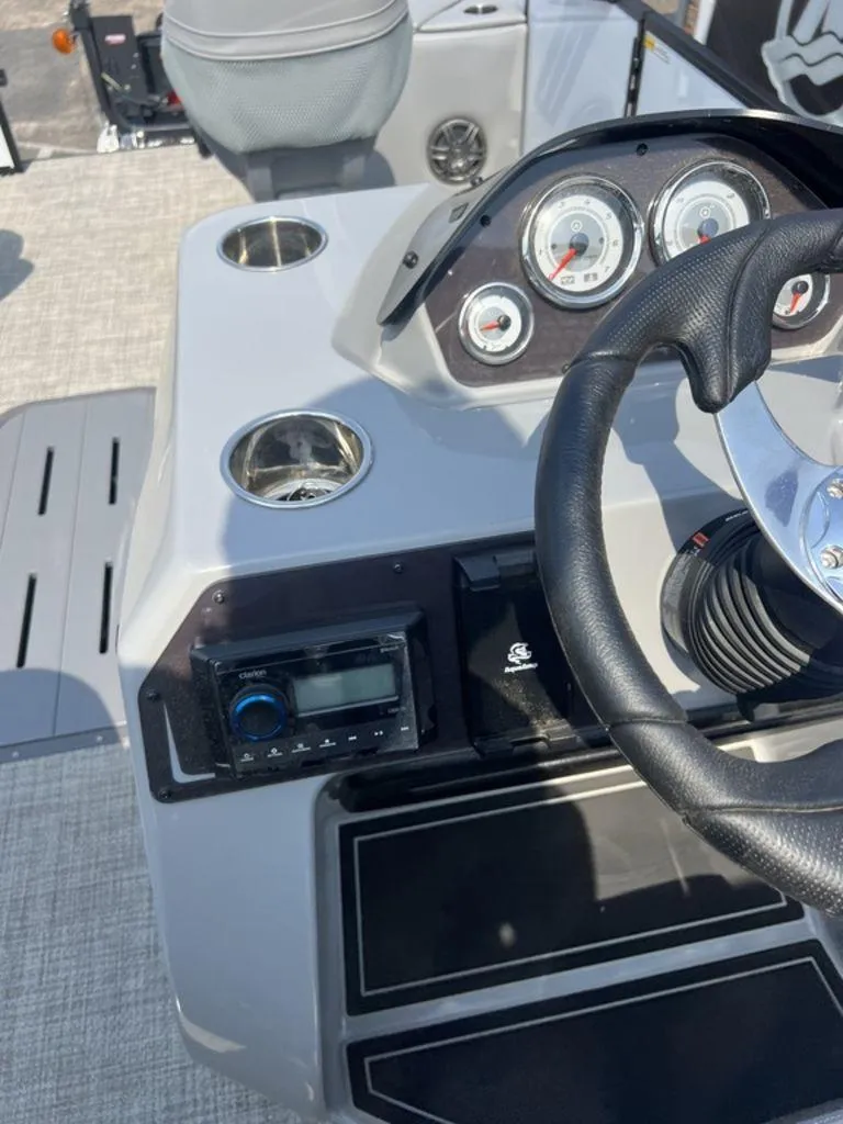 Slide: The Image of 2025 SunCatcher Fusion 322 FC boat dashboard with steering wheel and gauges. - 34