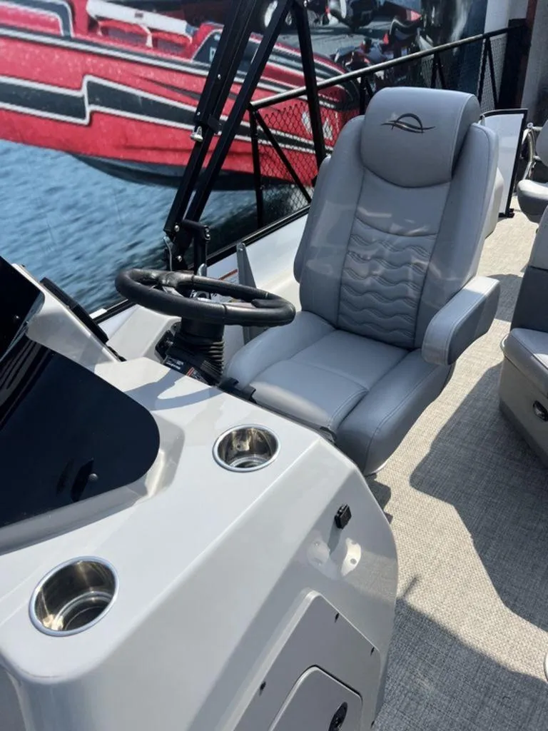 Slide: The Image of 2025 SunCatcher Fusion 322 FC boat interior with steering wheel and comfortable seating. - 45