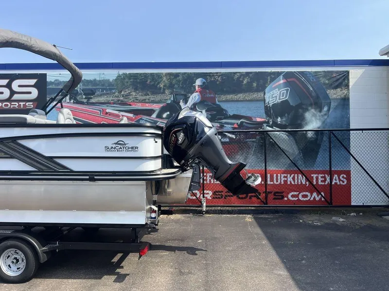 Slide: The Image of 2025 SunCatcher Fusion 322 FC boat on trailer, displayed outdoors near a sports advertisement. - 7