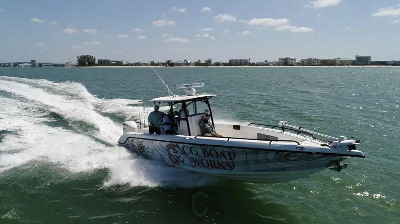 Slide: The Image of 2022 CG Boat Works 35 M-Series cruising on open water near a coastal city. - 12