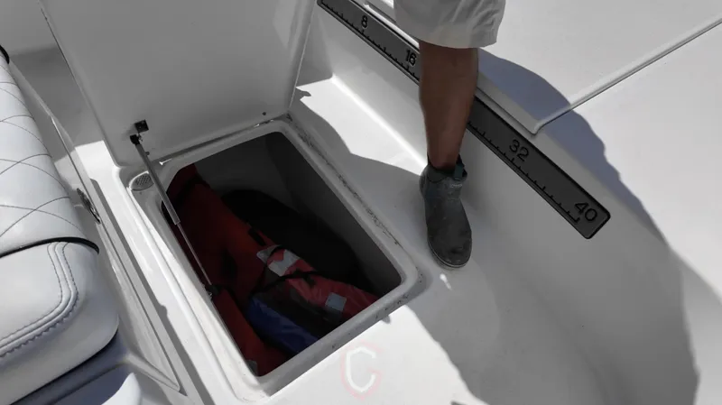 Slide: The Image of Open storage compartment on 2022 CG Boat Works 35 M-Series, showing life jackets inside. - 21