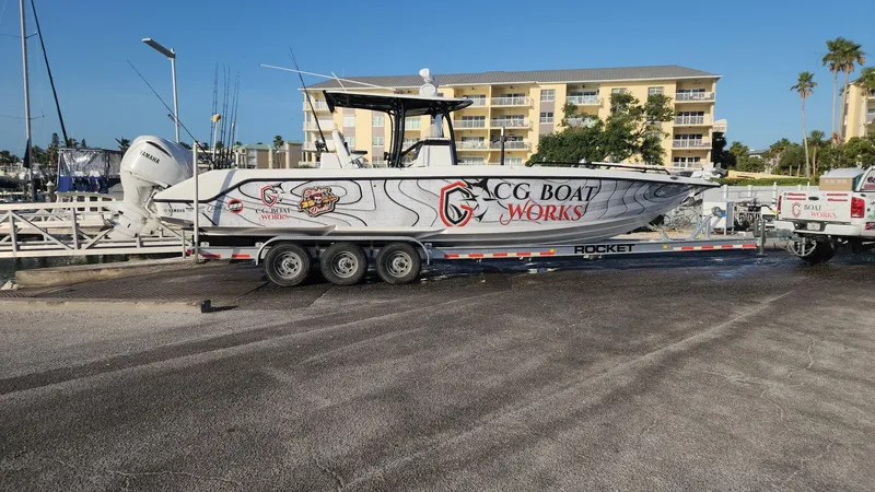 Slide: The Image of 2022 CG Boat Works 35 M-Series on trailer, parked near marina with buildings in background. - 48