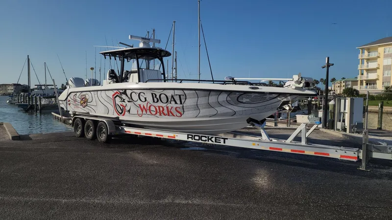 Slide: The Image of 2022 CG Boat Works 35 M-Series on trailer at marina, clear sky background. - 5