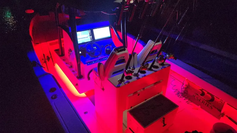 Slide: The Image of 2022 CG Boat Works 35 M-Series with vibrant red interior lighting at night. - 8