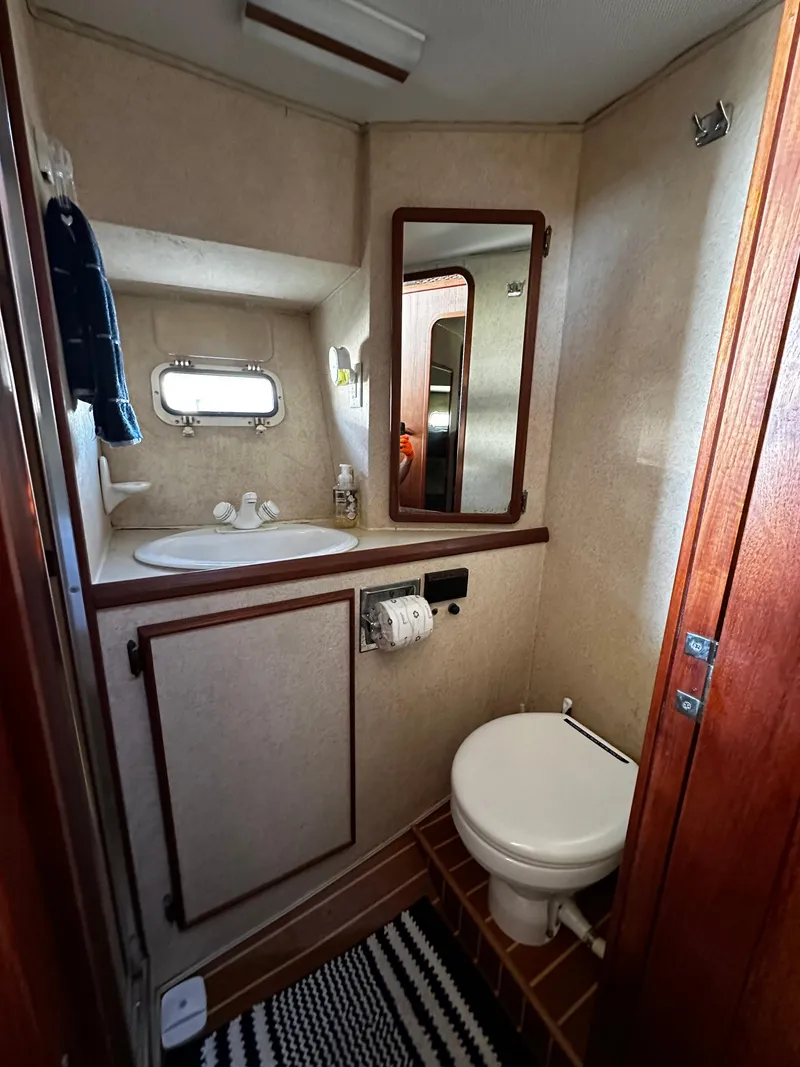 Slide: The Image of 1985 Chris-Craft 382 Commander bathroom with sink, mirror, and toilet. - 13