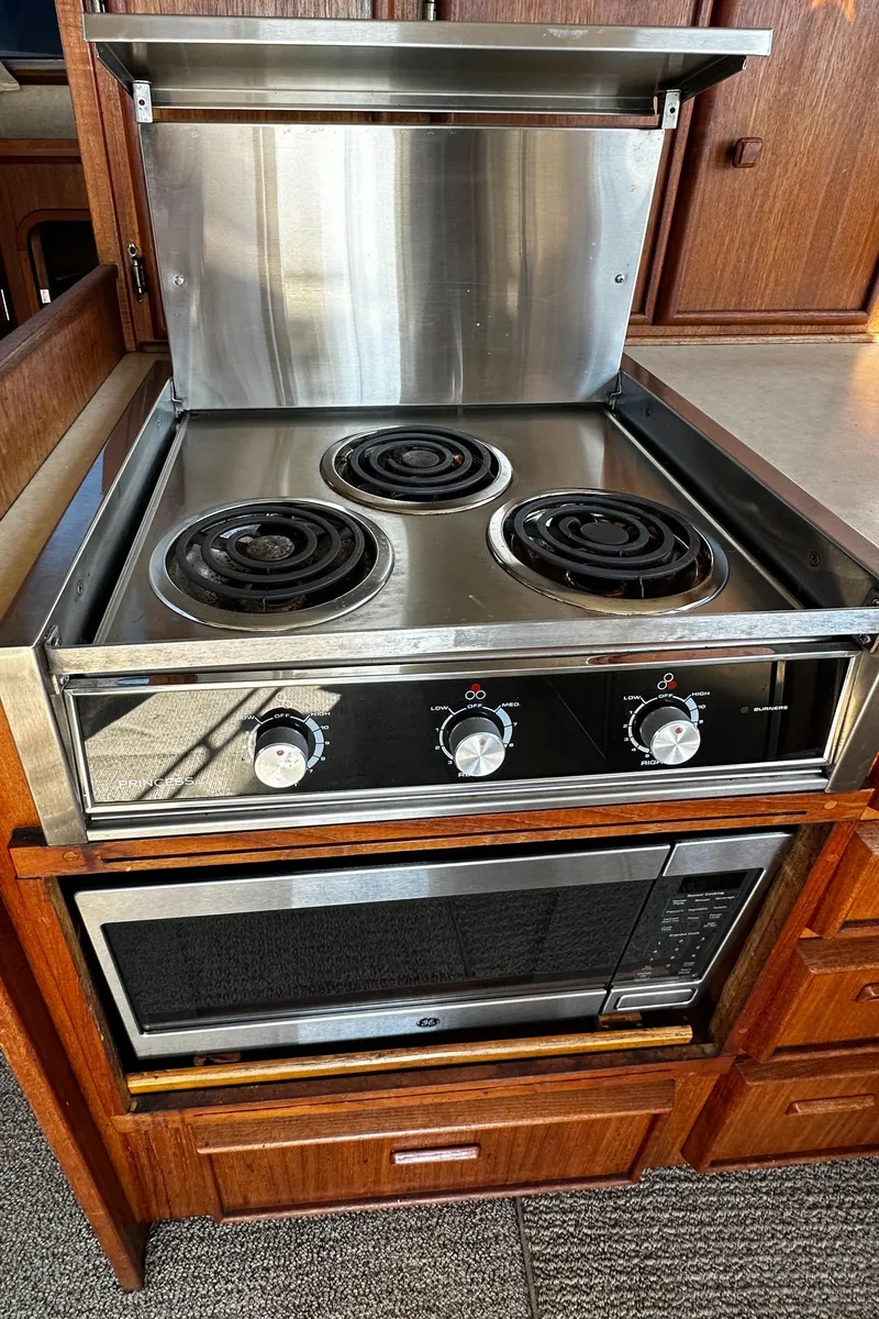 Slide: The Image of 1985 Chris-Craft 382 Commander kitchen with electric stove and oven, wooden cabinetry. - 15