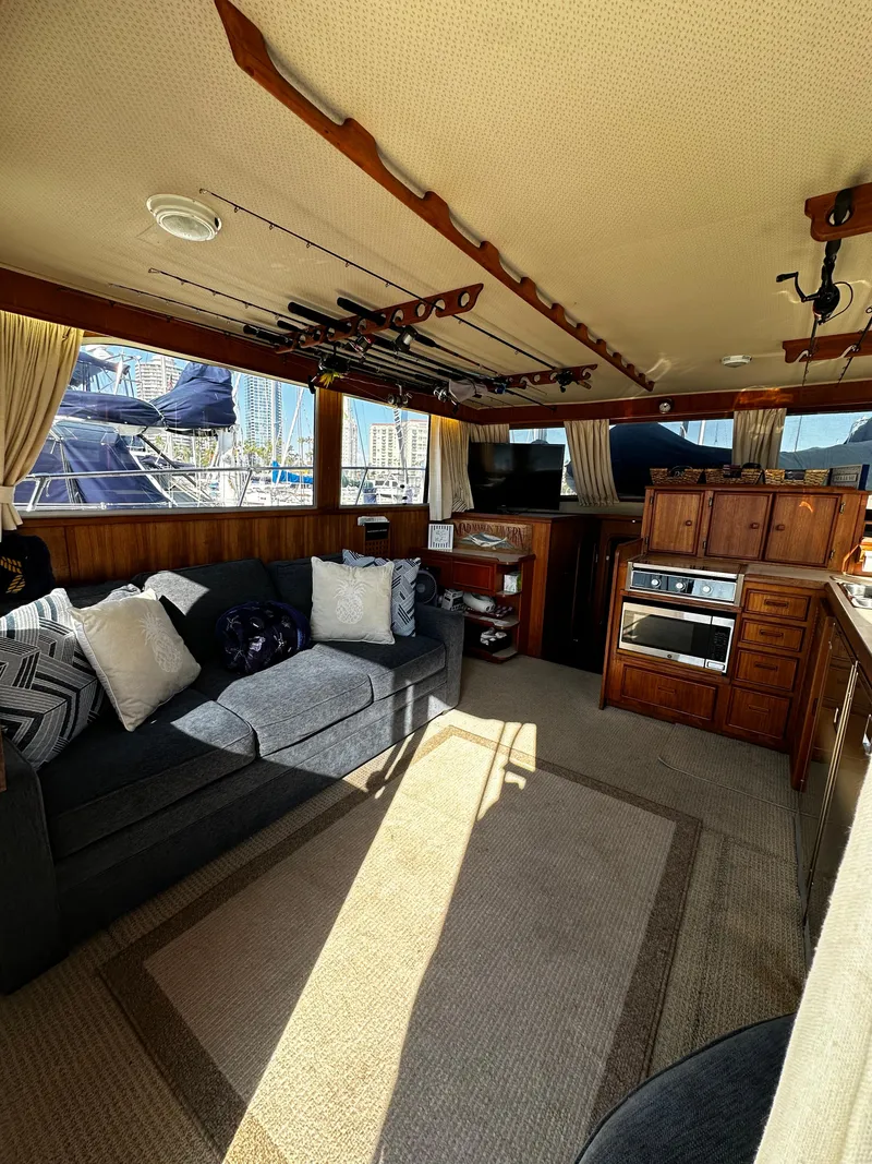 Slide: The Image of Interior of 1985 Chris-Craft 382 Commander with cozy seating and fishing rods. - 16