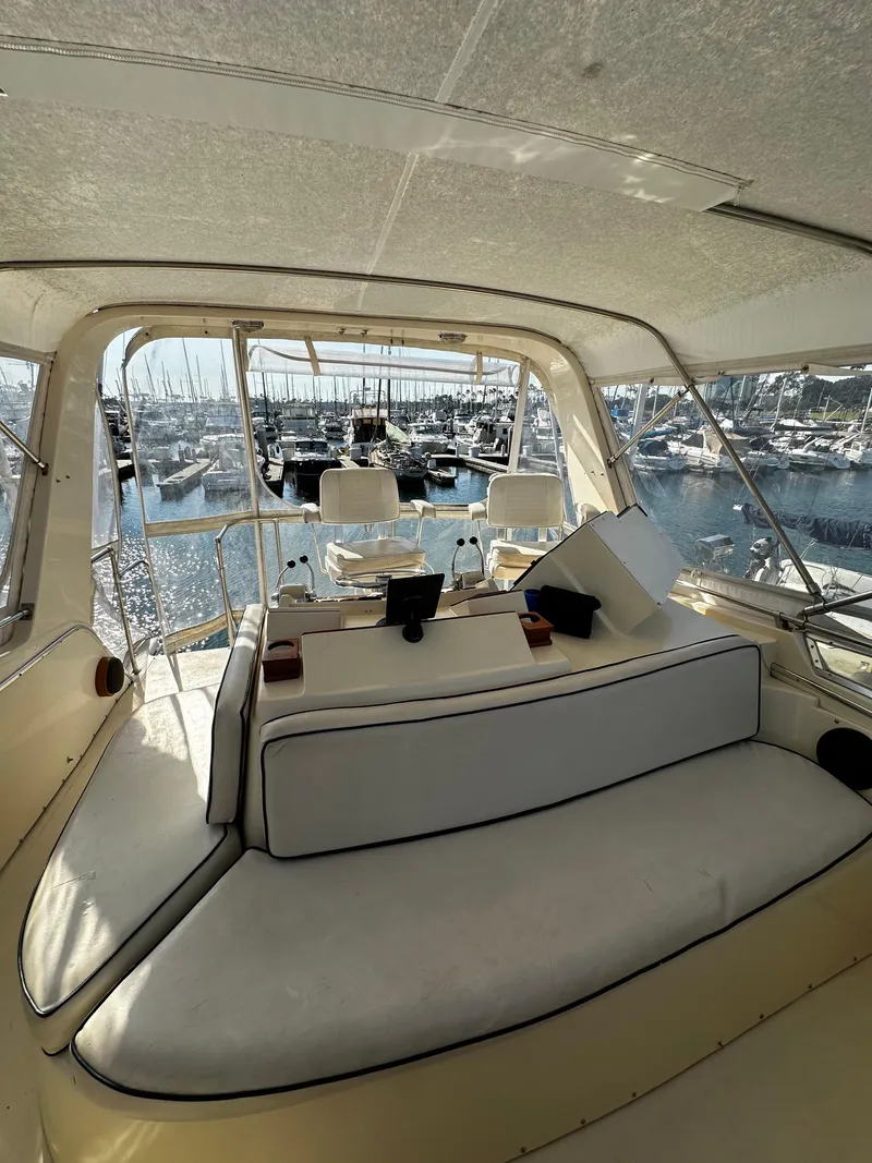 Slide: The Image of 1985 Chris-Craft 382 Commander interior with marina view, featuring seating and helm area. - 18