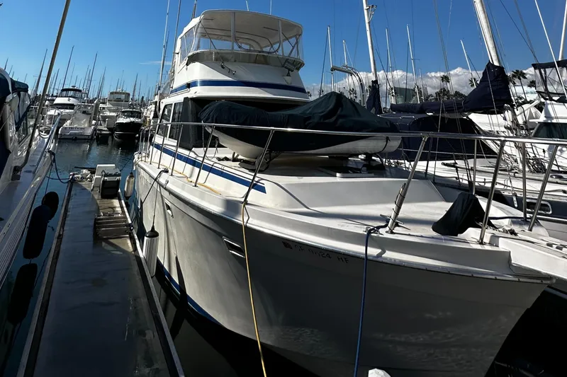 Slide: The Image of 1985 Chris-Craft 382 Commander yacht docked in a marina, surrounded by other boats. - 5