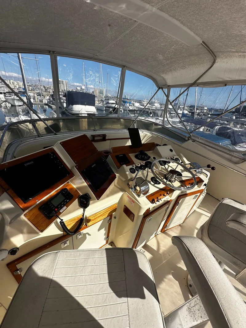 Slide: The Image of 1985 Chris-Craft 382 Commander yacht cockpit with navigation equipment and marina view. - 8