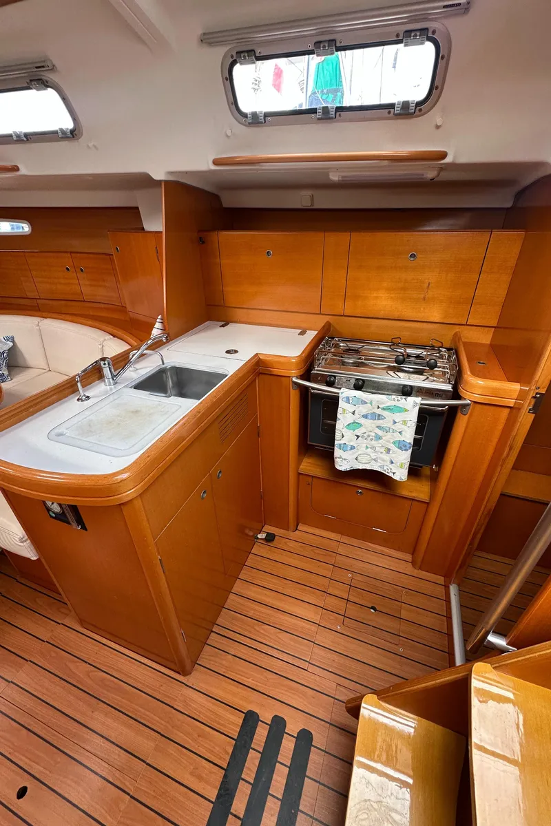 Slide: The Image of 2005 Beneteau First 44.7 yacht kitchen with wood finish, sink, and stove. - 20