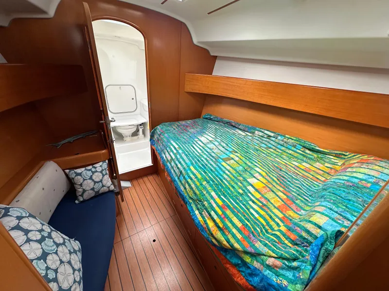 Slide: The Image of Cozy cabin interior of 2005 Beneteau First 44.7 sailboat with colorful bedding and wooden finish. - 28