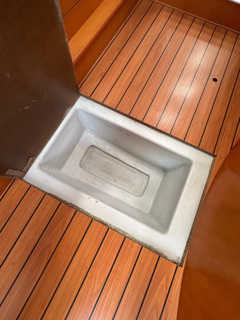 Slide: The Image of Beneteau First 44.7 (2005) interior with wooden flooring and built-in storage compartment. - 32