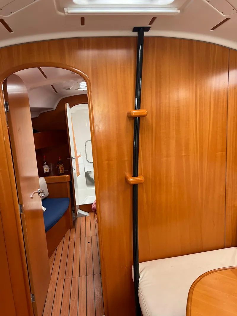 Slide: The Image of Interior of 2005 Beneteau First 44.7 sailboat, featuring wooden paneling and seating area. - 38