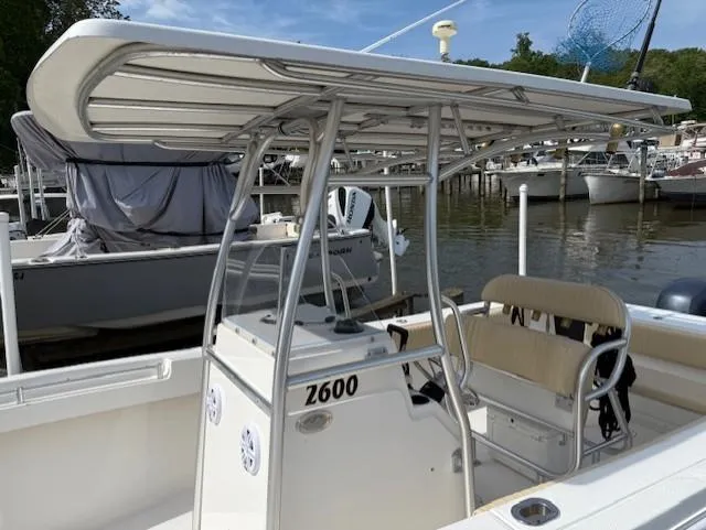 Slide: The Image of 2006 Angler 2600CC Limited Edition boat docked, featuring a T-top and seating area. - 4