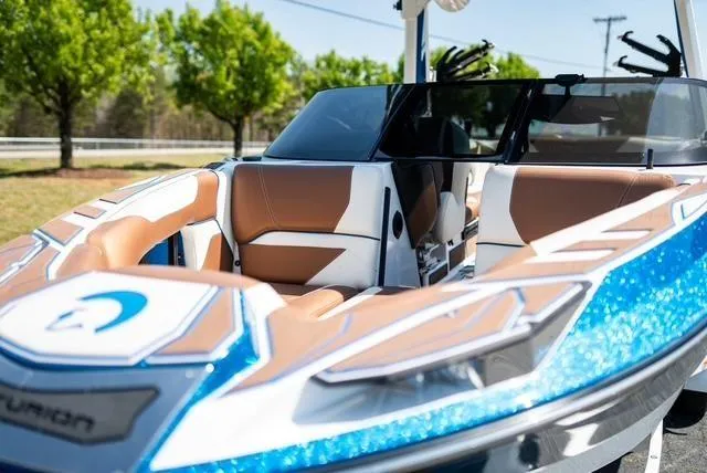 Slide: The Image of 2022 Centurion Ri265 boat with sleek design and luxurious seating, parked outdoors. - 11