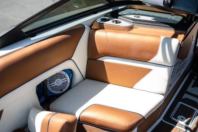 Slide: The Image of 2022 Centurion Ri265 boat interior with tan and white seating, cup holders, and speaker. - 15
