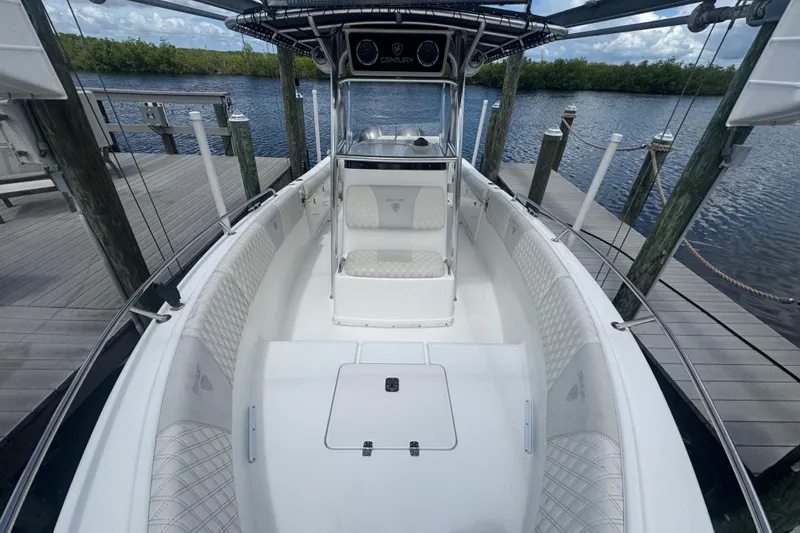 Slide: The Image of 2007 Century 2600CC boat docked by a wooden pier, featuring spacious seating. - 21