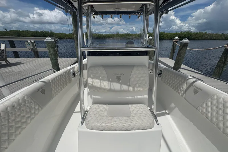 Slide: The Image of 2007 Century 2600CC boat interior with white quilted seats, docked by a scenic waterfront. - 23