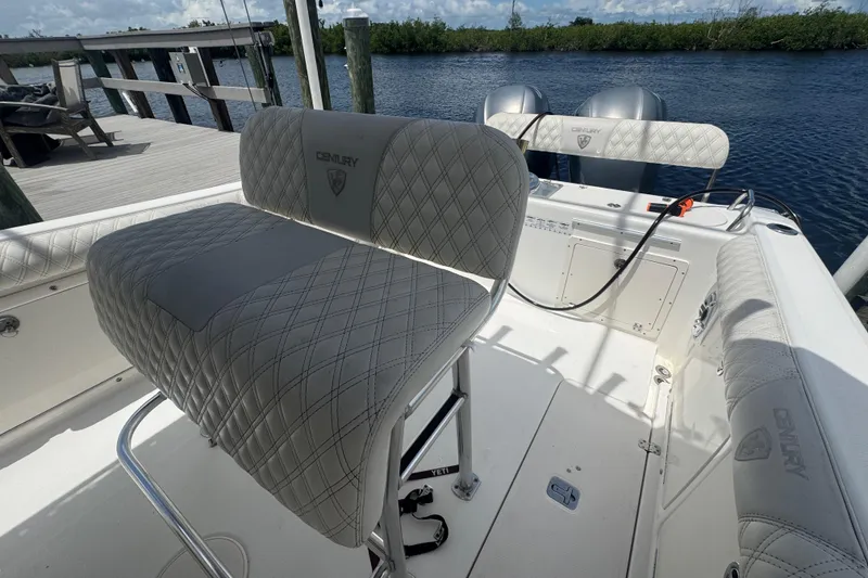Slide: The Image of 2007 Century 2600CC boat interior with quilted seating, docked by a serene waterway. - 28