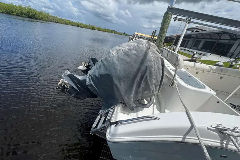 Slide: The Image of 2007 Century 2600CC boat docked by waterfront, covered engine, cloudy sky. - 30