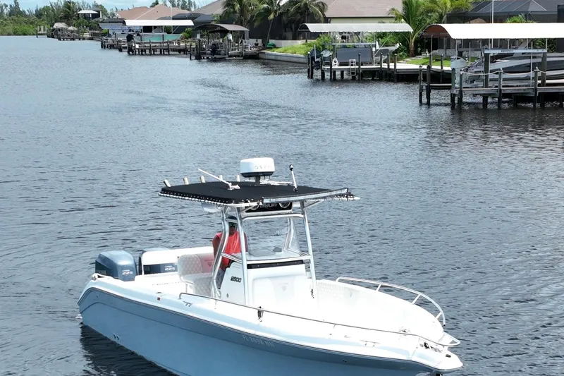 Slide: The Image of 2007 Century 2600CC boat on a calm waterfront with docks and houses. - 4