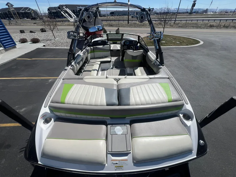 Slide: The Image of 2014 Malibu W22MXZ boat with spacious seating and modern design in a parking lot. - 10