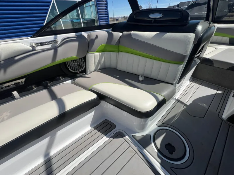 Slide: The Image of Interior of a 2014 Malibu W22MXZ boat with gray and green seating. - 14