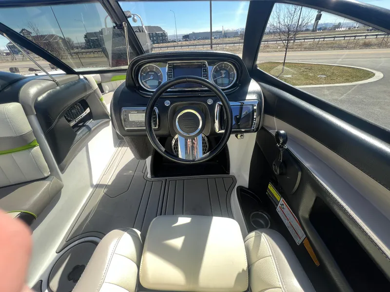 Slide: The Image of Interior view of a 2014 Malibu W22MXZ boat cockpit with steering wheel and controls. - 15