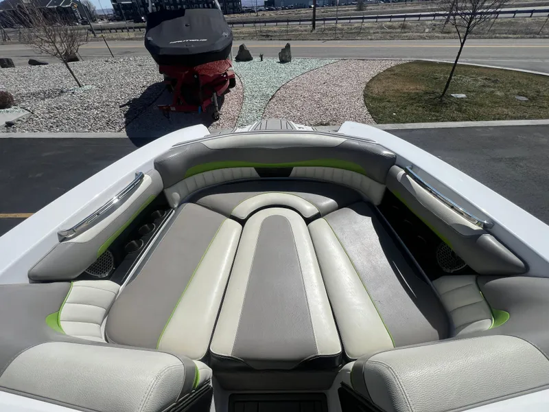 Slide: The Image of 2014 Malibu W22MXZ boat interior with gray and green cushioned seating. - 16