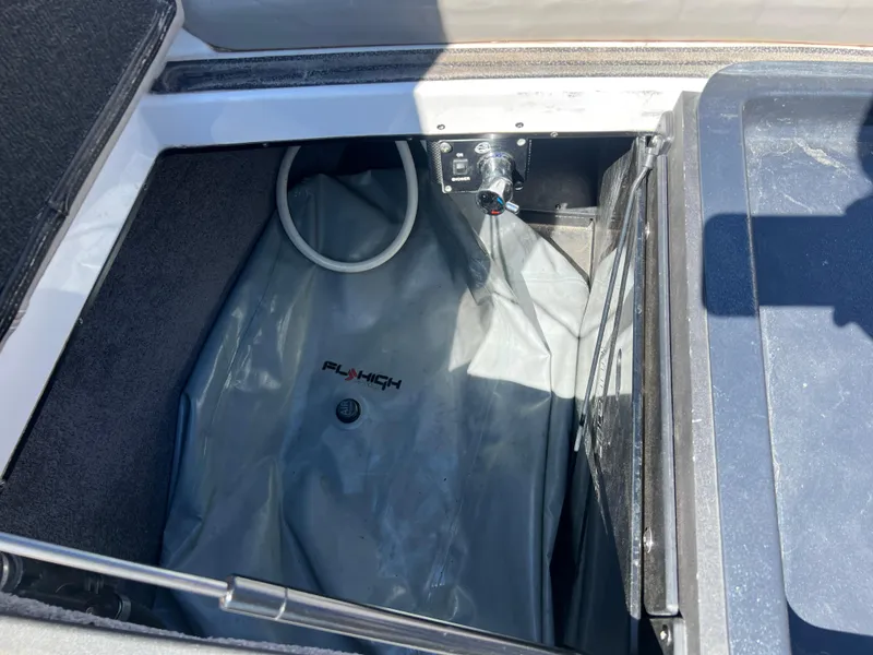 Slide: The Image of Open storage compartment in a 2014 Malibu W22MXZ boat with Fly High ballast bag. - 19