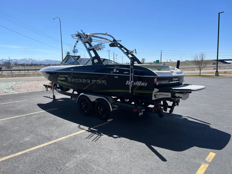 Slide: The Image of 2014 Malibu Wakesetter W22MXZ boat on trailer in parking lot, sunny day. - 7