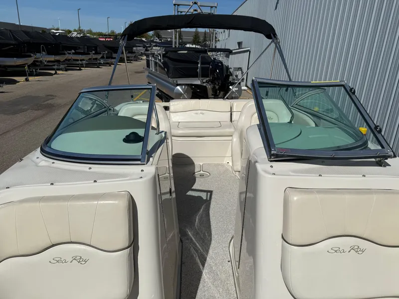 Slide: The Image of 2008 Sea Ray 220 boat with open deck and seating, parked outdoors. - 20