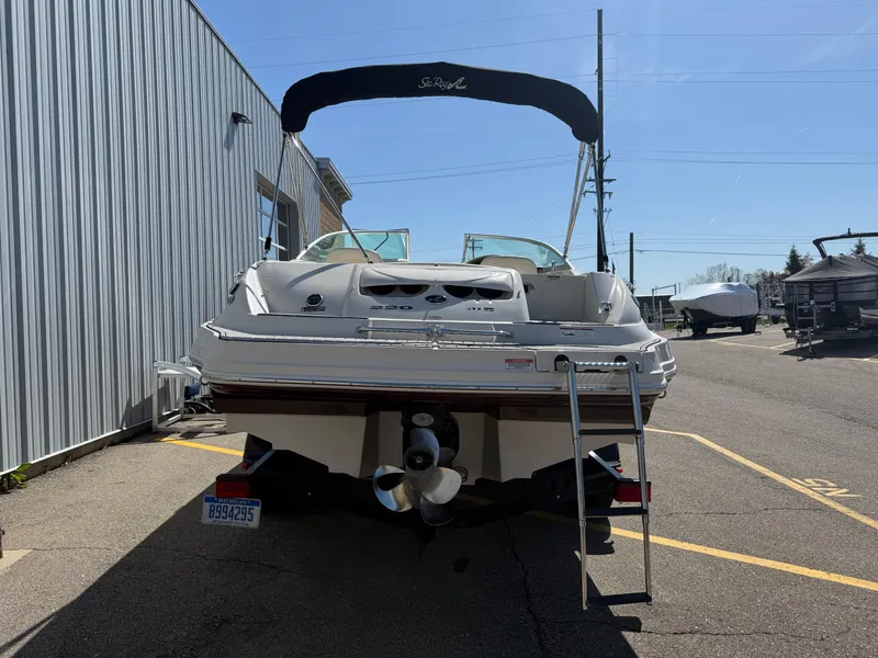 Slide: The Image of 2008 Sea Ray 220 boat with ladder, parked outdoors near a building. - 6