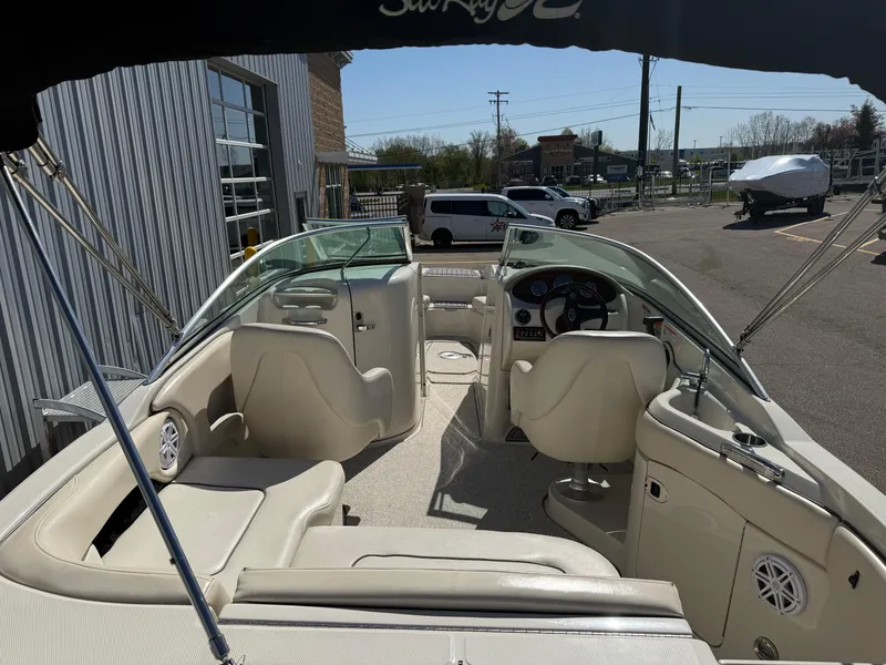 Slide: The Image of 2008 Sea Ray 220 boat interior with seating and steering wheel, parked outdoors. - 7
