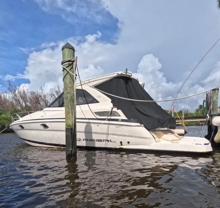 Slide: The Image of 2015 Regal 35 Sport Coupe docked on a sunny day with a cloudy sky. - 1