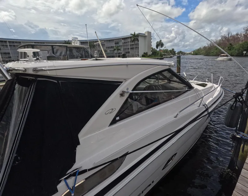 Slide: The Image of 2015 Regal 35 Sport Coupe docked by waterfront buildings under cloudy sky. - 11
