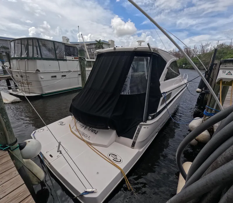 Slide: The Image of 2015 Regal 35 Sport Coupe docked in a marina under a partly cloudy sky. - 14