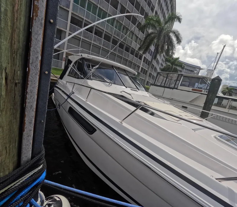 Slide: The Image of 2015 Regal 35 Sport Coupe docked near waterfront buildings and palm trees. - 17