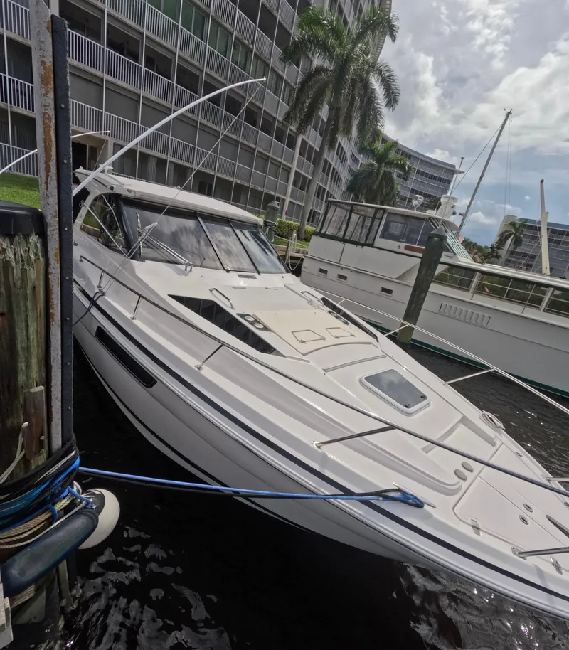 Slide: The Image of 2015 Regal 35 Sport Coupe docked near waterfront buildings and palm trees. - 18
