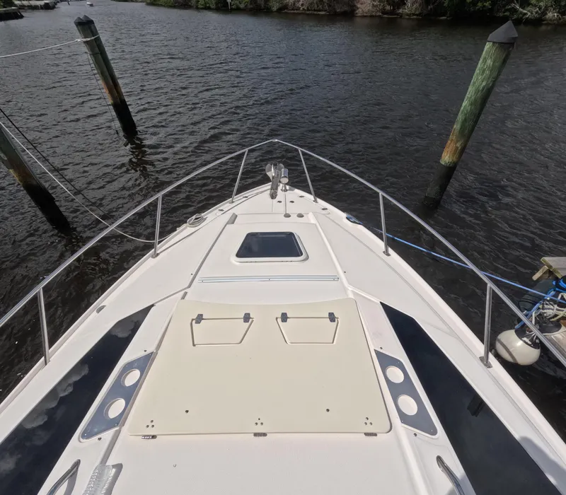Slide: The Image of 2015 Regal 35 Sport Coupe boat docked on calm water, viewed from the bow. - 20