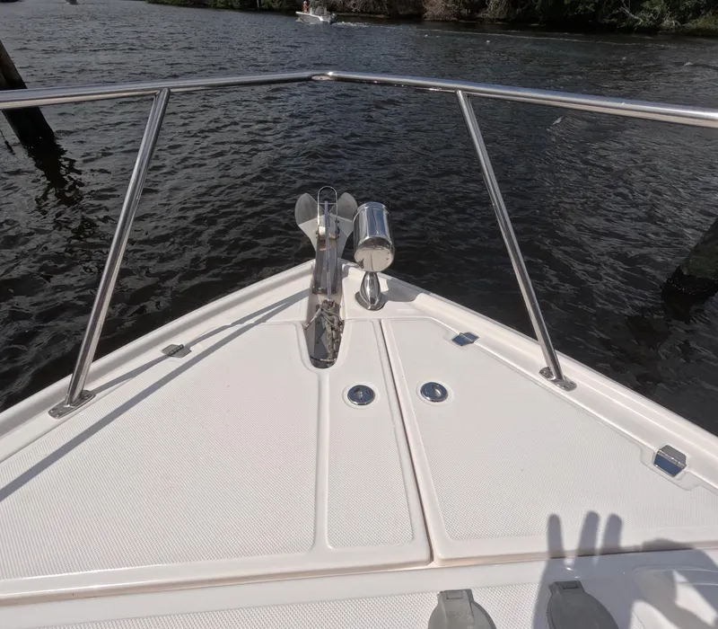 Slide: The Image of Bow view of 2015 Regal 35 Sport Coupe on water, featuring stainless steel railings. - 35