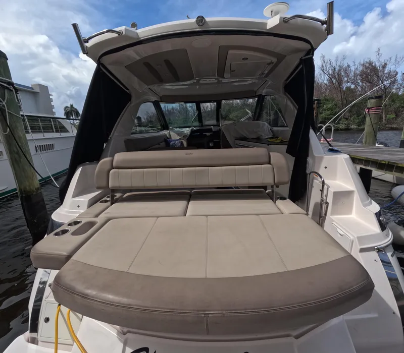 Slide: The Image of 2015 Regal 35 Sport Coupe boat with spacious rear seating and canopy, docked by the water. - 36