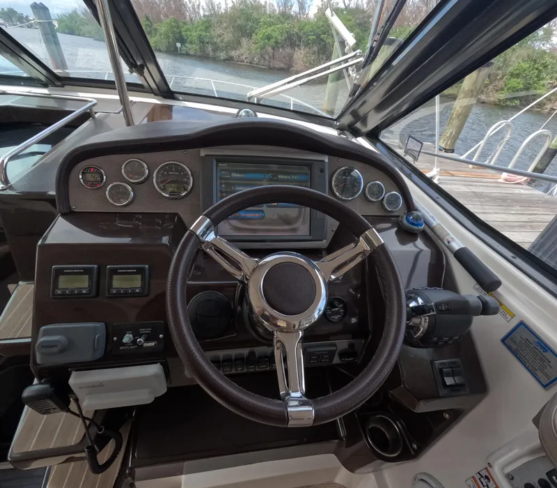 Slide: The Image of Helm of 2015 Regal 35 Sport Coupe with steering wheel and navigation controls. - 49