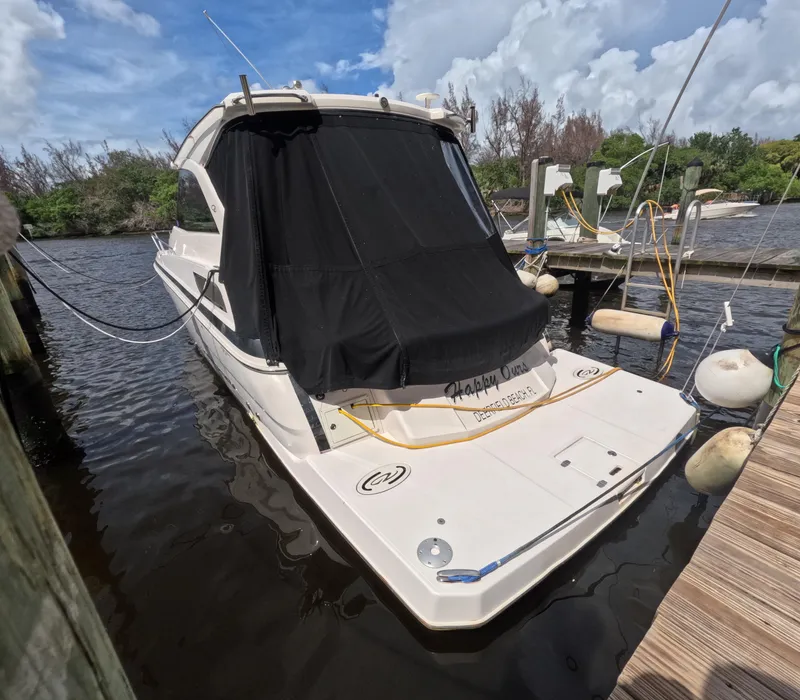 Slide: The Image of 2015 Regal 35 Sport Coupe docked at marina under blue sky. - 7
