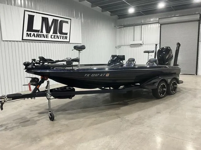 Slide: The Image of 2022 Skeeter FXR21 Select boat speeding on a lake with trees in the background. - 1