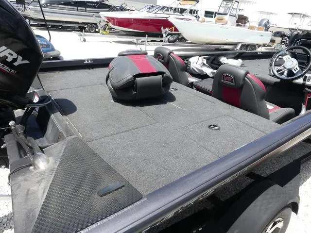 Slide: The Image of 2019 Ranger RT178C boat interior with seating and steering wheel, parked among other boats. - 4