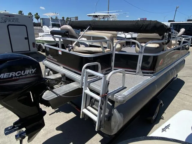 Slide: The Image of 2015 Sun Tracker 18 DLX pontoon boat with Mercury outboard motor, docked outdoors. - 4