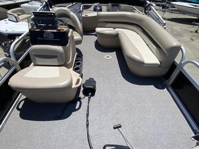Slide: The Image of 2015 Sun Tracker 18 DLX pontoon boat interior with beige seating and steering console. - 6