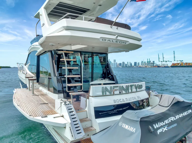 Slide: The Image of Galeon 500 Fly yacht, 2020 model, docked with city skyline in background. - 2